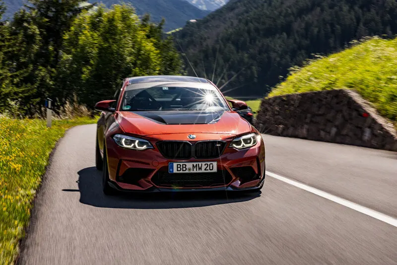 Oranger BMW M2 bei der Bergfahrt über einen österreichischen Alpenpass